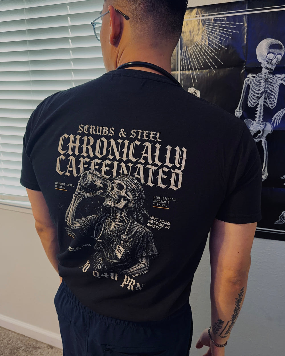 Chronically Caffeinated Nurse Tee in black — skeleton nurse in scrubs with a to-go coffee, cream distressed print on Comfort Colors 1717