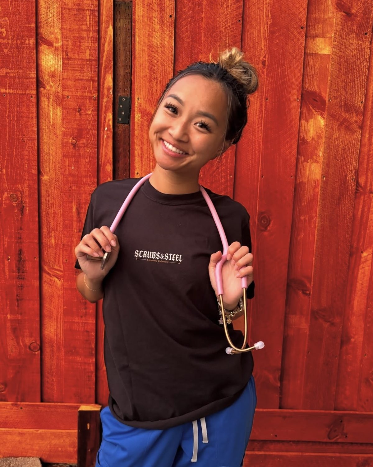 Nurse in blue scrubs wearing a Scrubs & Steel tee with a stethoscope