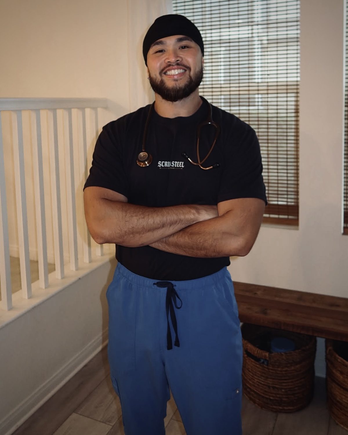 Nurse in scrubs and a scrub cap wearing the Scrubs & Steel front-logo tee with a stethoscope